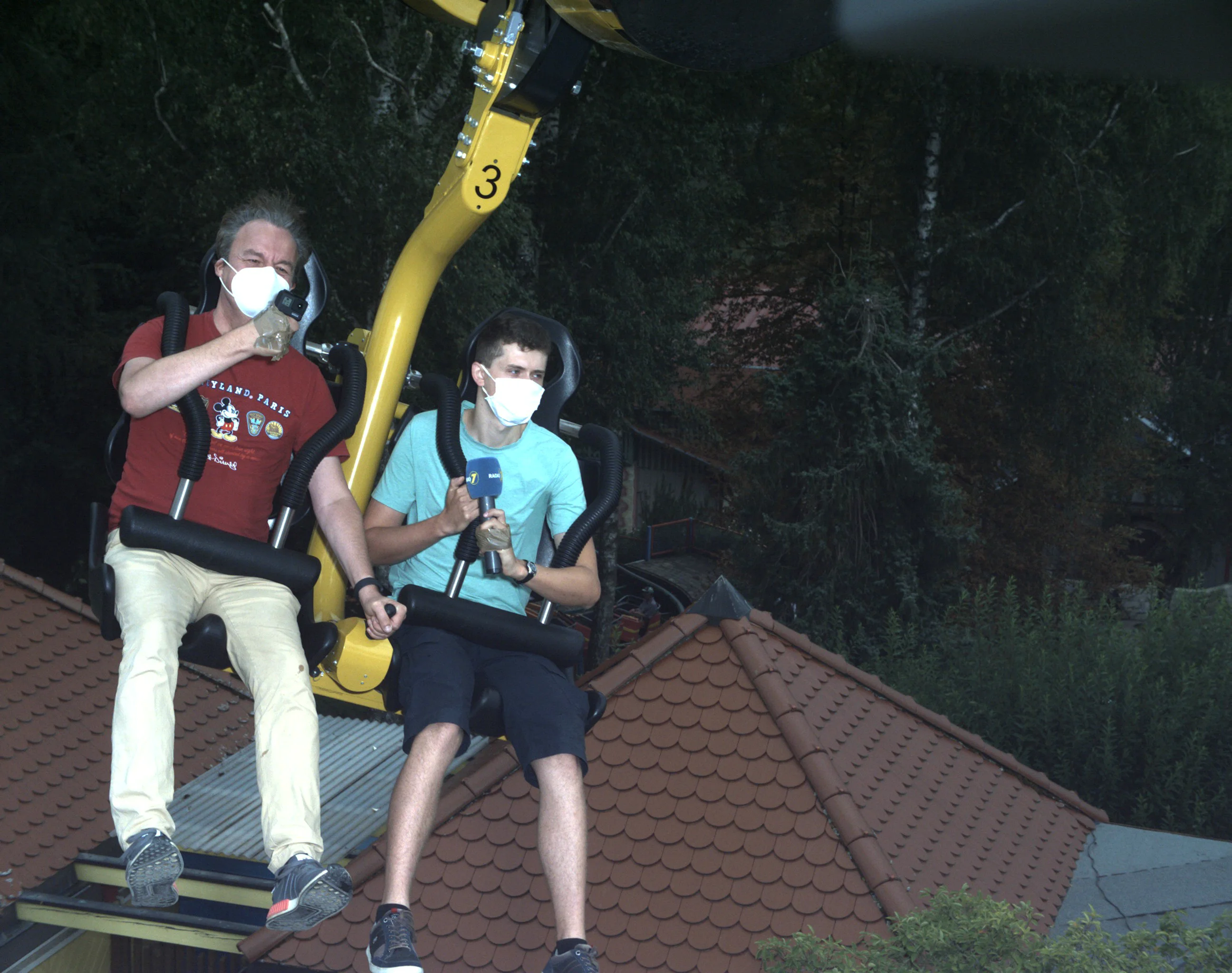 Schwebebahn mit Fahrgaesten auf einer haengenden Attraktion